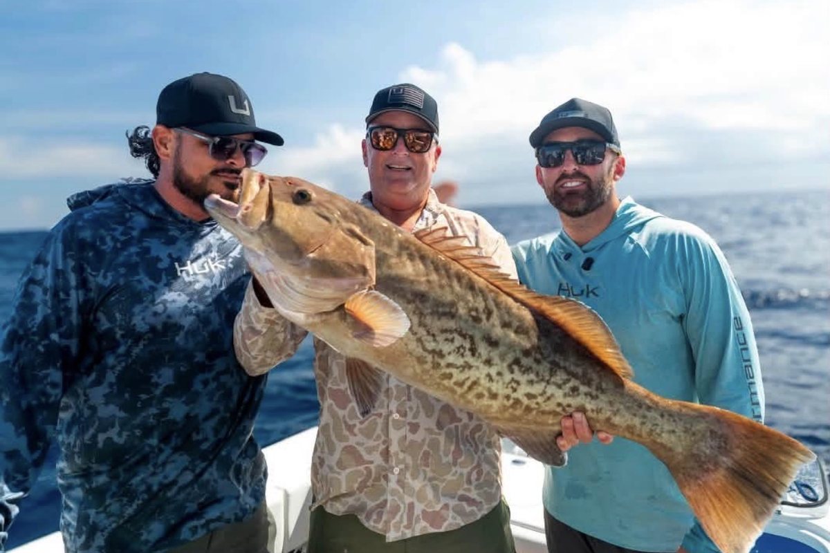 James Marko, Mike Dillon and Austin Dillon holding a large gag grouper offshore